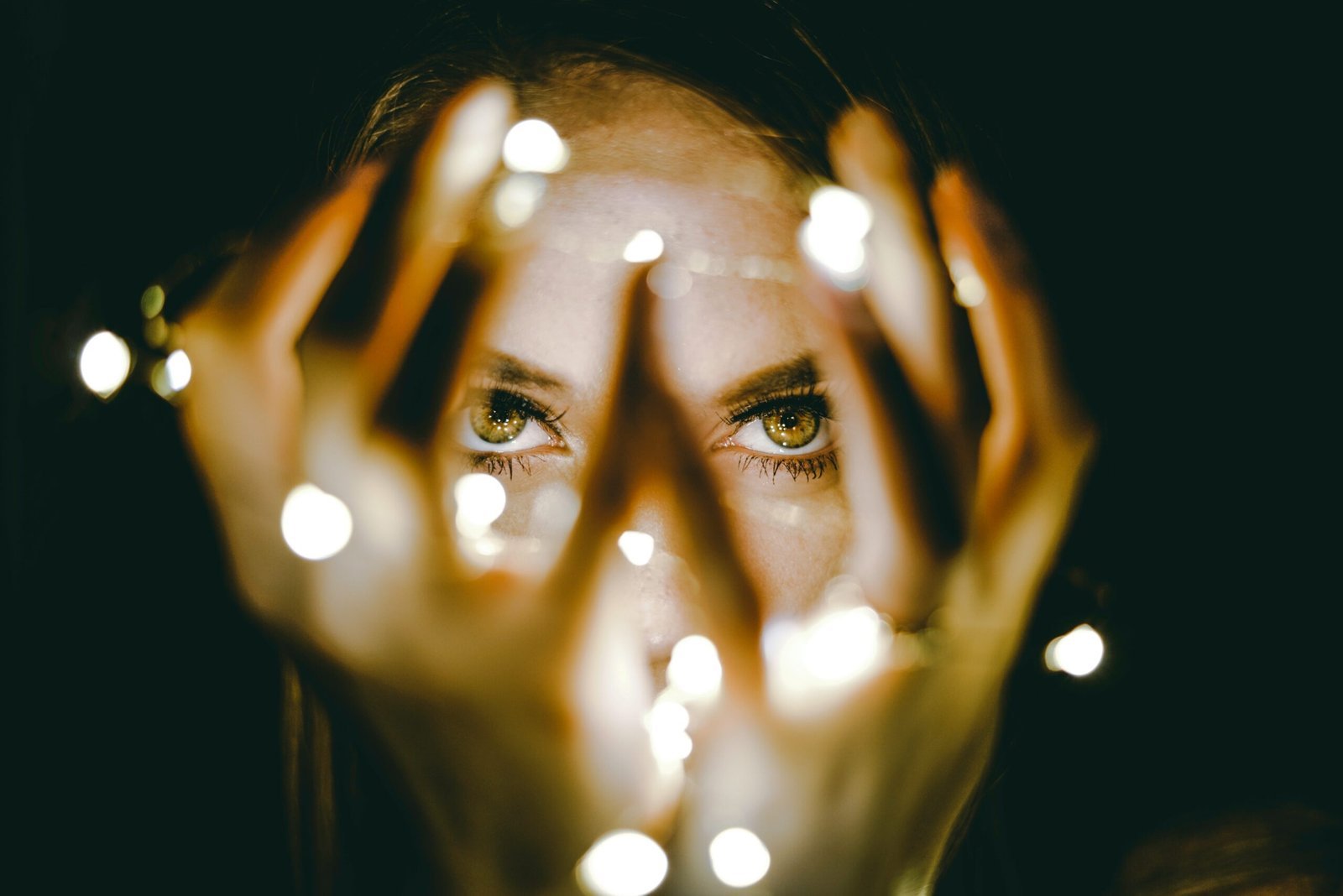 woman holding string lights